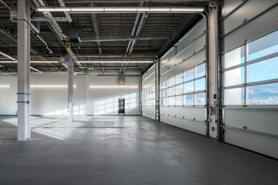 Interior shot of the bay doors with the sun shining inside at the Kelowna International Airport Operations and Emergency Services Building.