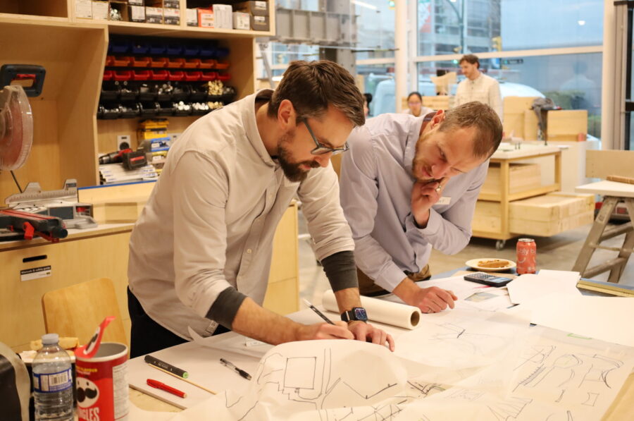 Architects and engineers collaborating on drafting design concepts during the workshop.