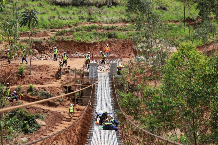 Bridges to Prosperity Ngayake Trail Bridge Build, progress construction image of people working on the decking of the bridge